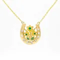 Close-up of golden horseshoe necklace with daffodil flowers and green gemstones - March Daffodil Horseshoe Necklace