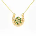 Detailed view of a gold horseshoe necklace with an emerald and diamond rose pendant - June Rose Horseshoe Necklace