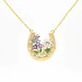 Detailed view of a golden horseshoe necklace with intricate colorful floral inlay - July Blue Water Lily Horseshoe Necklace