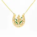 Detail shot of a luxury gold horseshoe necklace with floral motif and green enamel. - August Lily Horseshoe Necklace