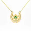 Detailed close-up of a gold-plated horseshoe necklace featuring a green gemstone flower center - December Narcissus Horseshoe Necklace