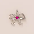 Close-up detail of a silver stainless steel bow charm pendant with a pink heart gemstone. - Flowing Bowknot Pendant / Steel