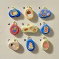 Macro view of nine numbered pebble pendants with hand-painted sushi and bread food designs - Breakfast Platter Pendant