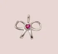 Detailed macro view of a silver-toned stainless steel bow charm with red heart stone - Rose Red Bow Pendant / Steel