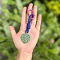 Handcrafted tropical Monstera leaf bag charm featuring a blue rope knot and pink carabiner - Monstera Leaves / Green