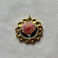 Detailed macro view of a vintage golden floral ceramic pendant on white linen background. - Lotus Pendant