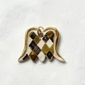 Macro view of a ceramic wing pendant with gold edges and a hand-painted harlequin pattern - Dropped Wing Pendant