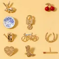 Assortment of vintage gold-toned brooches including cherry, rabbit, and cowboy boot designs - Rabbit Style