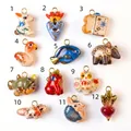 Detailed view of 12 unique hand-painted ceramic animal charms with gold metal loops - 1-colored rabbit pendant / Colorful