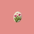 Detalle de un colgante ovalado blanco con motivos florale rosas pintados a mano. - Flor Rosa