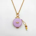 Detalle del collar de medallón de esmalte lavanda con lazo dorado y amuleto de niña - Girl Locket Necklace / Púrpura