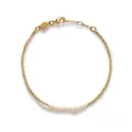 Détail haute résolution d'un bracelet minimaliste en perles dorées avec petites perles - Style Perle de Riz Tube d'Or / Or