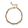 Vue détaillée d'un bracelet minimaliste en perles dorées avec un charm en perle fine - Style Perlé Doré / Or
