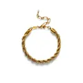 Détail d'un bracelet en chaîne torsadée dorée minimaliste avec une petite perle blanche. - Style Chaîne Torsadée Épaisse / Or