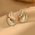 Gros plan d'élégantes boucles d'oreilles éventail dorées avec des accents de zircone. - Style Éventail Tordu (LY-0895) / Or 18 carats