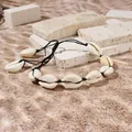 Dettaglio ravvicinato del bracciale fatto a mano con conchiglie e un cordino nero - Bracciale in Cordino Nero / Nero