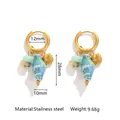 Detail view of oceanic conch and shell charms on gold stainless steel hoop earrings - Blue