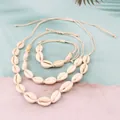 Vista dettagliata di un set di gioielli in conchiglia intrecciata con collane e bracciale - Set di 3 pezzi / Bianco