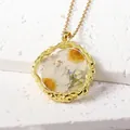 Elegant gold-tone necklace with real daisy flower resin pendant and gold flakes detail - April