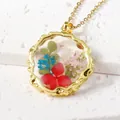 Elegant handmade resin necklace with real dried red and blue flowers in a gold frame - June