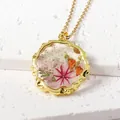 Elegant gold-plated necklace featuring pink dried flowers in a round resin pendant - September