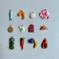 Close-up view of hand-painted colorful dopamine charms including food and fruit shapes - Blue Fish Pendant