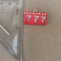 Detail view of red rectangular 777 pendant next to a ruler for size - Triple Seven Number Pendant Only (Without Chain)