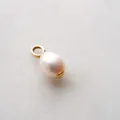 Detail eines tropfenförmigen Perlenanhängers mit vergoldetem Edelstahlelement - Anhänger mit Kunstperle / Gold