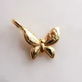 Detailaufnahme eines goldenen Schmetterlingsanhängers aus Edelstahl mit Prägemuster - Schmetterlingsanhänger / Gold
