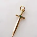 Detailansicht eines goldenen Schwertanhängers aus Edelstahl mit grünem Zirkonia-Inlay - Schwert Strass-Anhänger / Gold