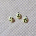 Detailed view of three oval ceramic pendants with blue floral designs on purple gingham background - 11 Blue Flower Pendant