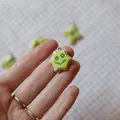 Close-up of a small handmade yellow ceramic star charm with blue flower pattern being held. - 12 Blue Flower Pendant