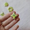 Close-up of a handmade yellow star-shaped ceramic pendant held in hand to show detail - 13 Flower Pendant