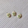 Close-up of handmade oval ceramic pendants with delicate floral design on gingham - 7 Oval Pink Flower Pendant