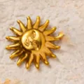 Dettaglio macro del ciondolo a sole in acciaio dorato con incisione del viso. - Vintage Anthropomorphic Sun Pendant / Oro