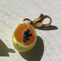 Detailopname van een realistische papaya bedel met een gouden karabijnsluiting - Papaja Hanger Zonder Ketting