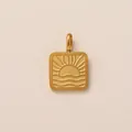 Primo piano di un ciondolo quadrato in acciaio inossidabile dorato con motivo sole - Square Sun Sunset Pendant / Oro