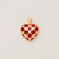 Gros plan d'un pendentif en forme de cœur avec un motif en émail rouge et or à damier. - Pendentif Cœur à Carreaux