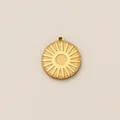 Dettaglio di un ciondolo tondo minimalista in acciaio inossidabile dorato con sole - Embossed Sun Ray Disc / Oro