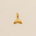 Nahaufnahme eines minimalistischen goldenen Walflossen-Anhängers aus Edelstahl für Ketten - Fischschwanz-Anhänger