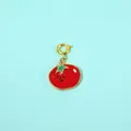 Macro detail of cute cartoon tomato pendant featuring red enamel and a gold-plated clasp - Tomato Vine Pendant
