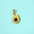Close-up of cute avocado enamel pendant with a smiley face on a blue background - Avocado Pendant