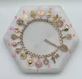 Detailed macro view of a gold stainless steel charm bracelet with 12 unique charms - Eye Pendant