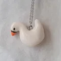Detailed close-up of a white swan dripping oil pendant on a stainless steel chain - White Goose Pendant