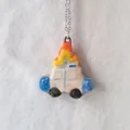 Detail shot of a minimalist white house pendant with colorful flame top and oil drop finish - House Charm