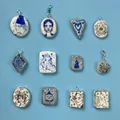 Macro detail of twelve unique illustrated ceramic pendants in diverse artistic shapes - Hat Portrait Pendant (MTPK254611Q)