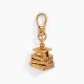 Detailed close-up view of a vintage gold graduation cap and stacked books metal charm - Book and Graduation Cap Charm