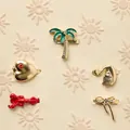 Verschiedene goldene Schuhanhänger mit Motiven wie Palme, Herz und Hummer für DIY-Deko - Flusskrebs
