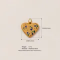 Gros plan d'un pendentif coeur en acier inoxydable jaune avec motif cerise bleue - Pendentif cœur
