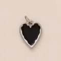 Close-up detail of a minimalist silver heart-shaped pendant with smooth black enamel filling - Black Heart